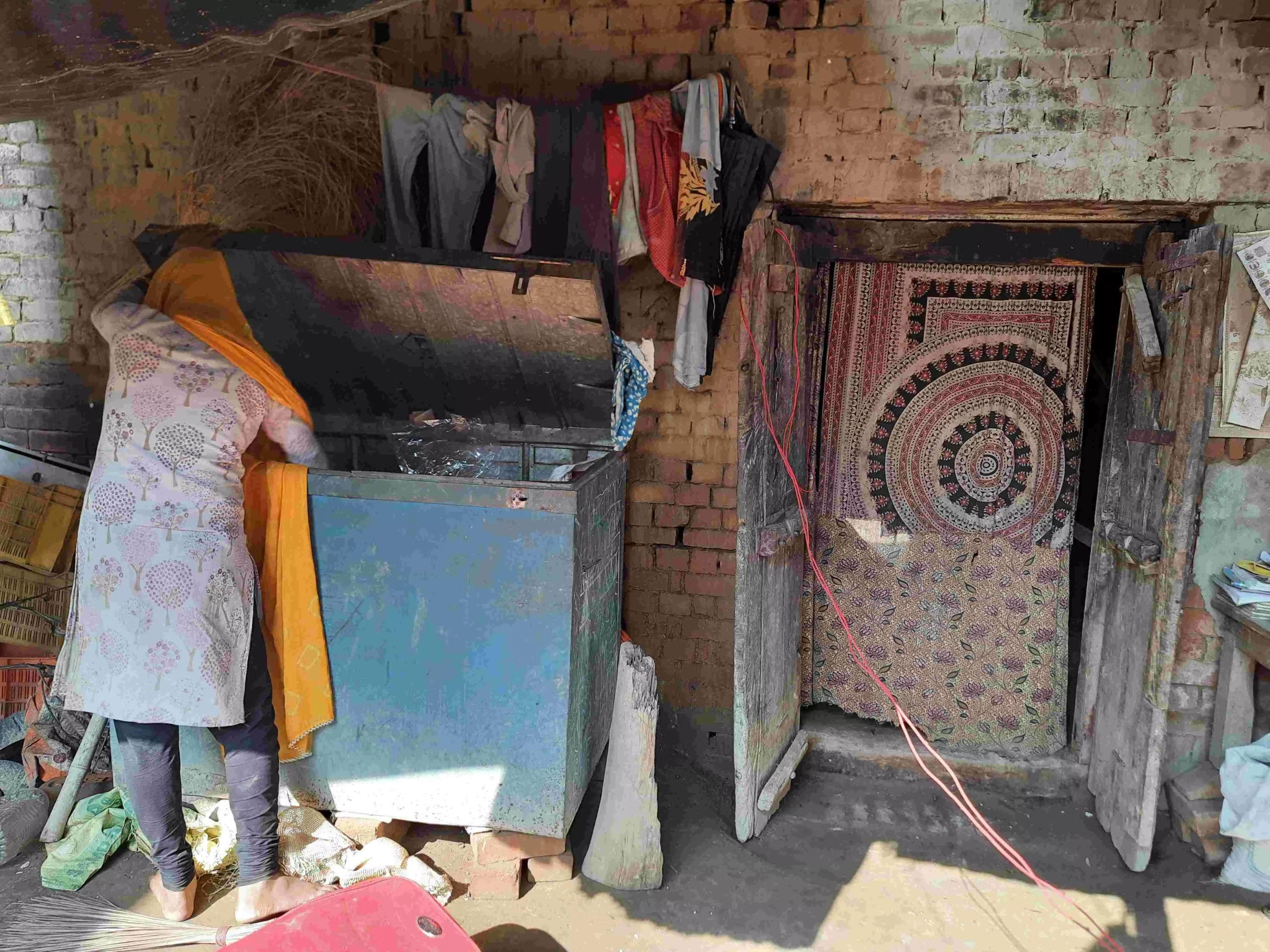 The rape survivor digging for her school uniform in the large trunk. Photo: Shivani Gupta