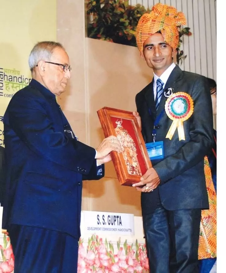 Om Prakash recieving recognition for his contributions in the pottery field.